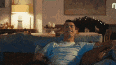a man is sitting on a couch with his arms outstretched
