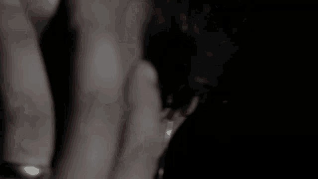 a close up of a person 's hand with a ring on it and smoke coming out of it .