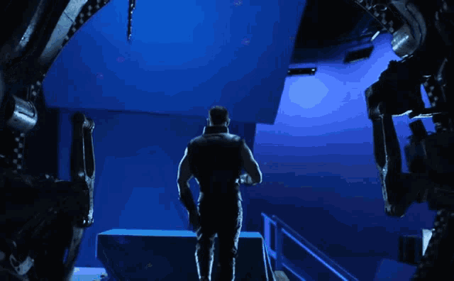 a man stands in front of a blue wall