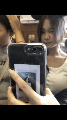 a woman is taking a picture of herself in a clear phone case