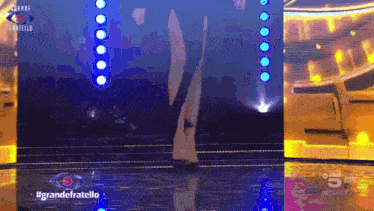 a tv screen shows a person on a stage and the words grande fratello