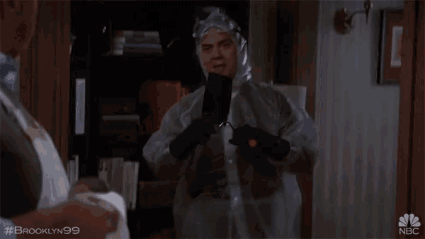 a man in a protective suit is talking to another man with the hashtag #brooklyn99