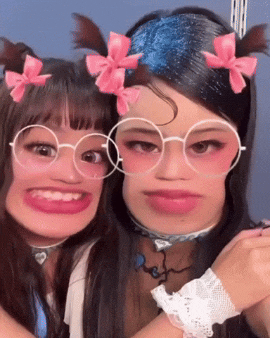 two girls wearing glasses and pink bows on their hair are posing for a picture