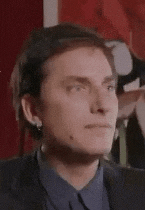 a close up of a man 's face with his eyes closed in a suit and blue shirt .
