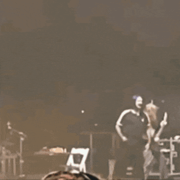 a woman wearing headphones is watching a band perform on stage