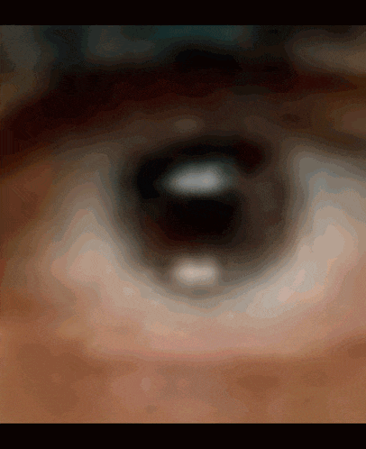 a close up of a person 's eye with a blurred image