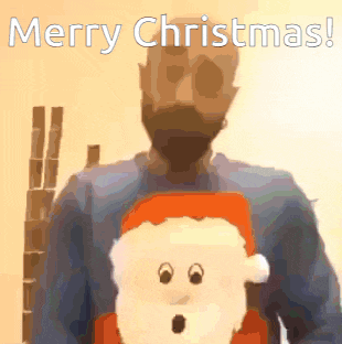 a man in a blue sweater is holding a stuffed santa claus and says merry christmas