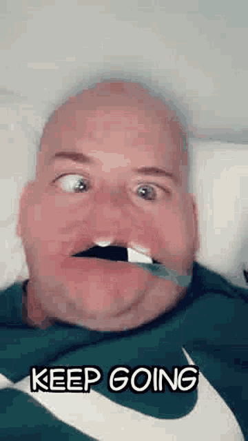 a bald man is laying in bed with a bandage on his mouth and says `` keep going '' .