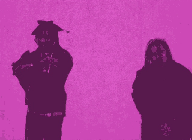 two men are dancing in front of a purple wall