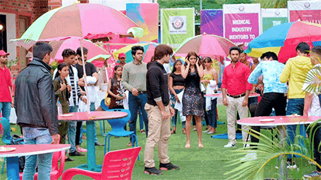 a group of people are standing under umbrellas in front of a medical industry sign