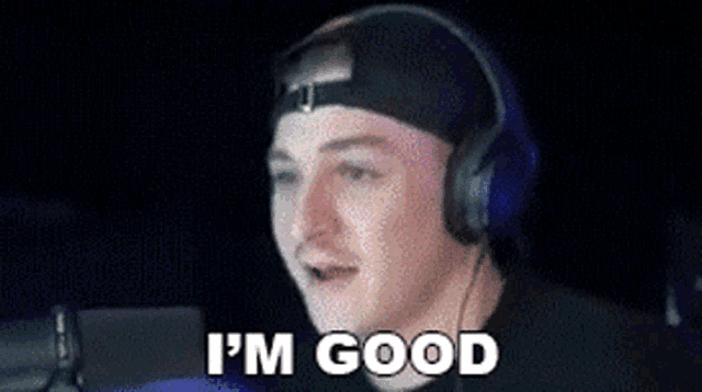 a man wearing headphones is saying i 'm good in a dark room .