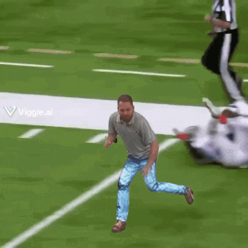 a man in a grey shirt and blue jeans is dancing on a field
