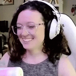 a woman wearing headphones and glasses is smiling and looking at the camera .