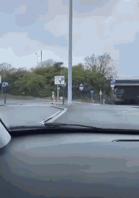 a car is driving down a street with a sign that says ' a ' on it .