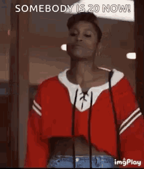 a woman in a red sweater is dancing with the words `` somebody is 20 now '' written above her .