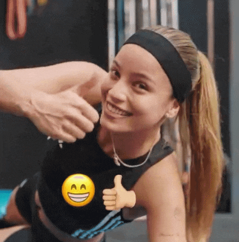 a woman is smiling and giving a thumbs up while a man holds her arm .