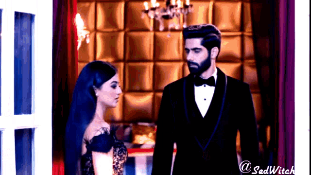 a man in a tuxedo and a woman in a black dress standing next to each other
