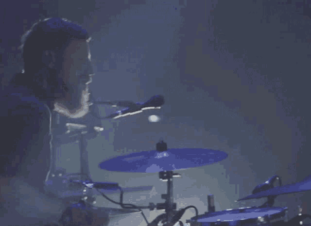 a man with a beard is playing a drum set
