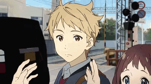 a boy and a girl are standing next to each other and the boy is looking at something