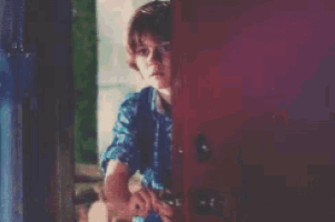 a young boy wearing a blue plaid shirt and a backpack