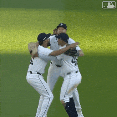 a group of baseball players hugging each other on the field