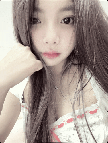 a girl with long hair is wearing a white top