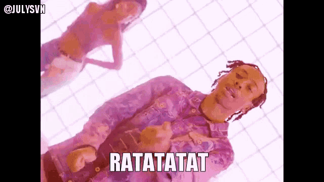 a man in a purple shirt is playing a guitar and the words ratatatat are above him .