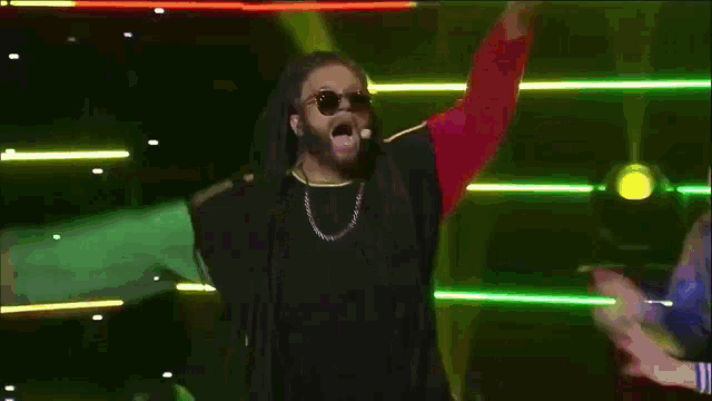 a group of people are dancing in front of a pink and green background