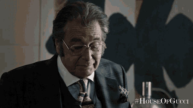 a man wearing glasses and a suit is featured in a house of gucci poster