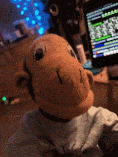 a stuffed monkey is sitting in front of a computer