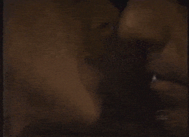 a man and a woman are kissing in front of a mirror .