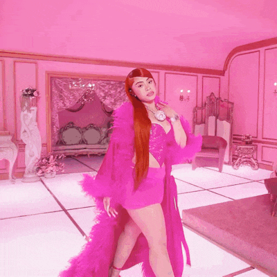 a woman in a pink outfit is standing in a room with pink walls