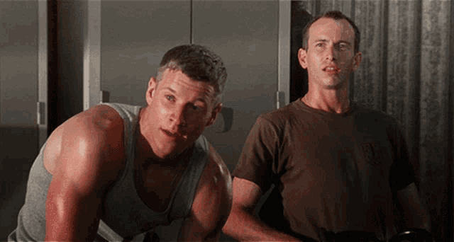 two men standing next to each other with one wearing a t-shirt that says ' us marines ' on it
