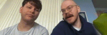 two men are sitting next to each other in a living room .