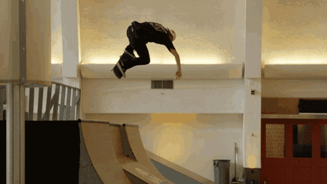 a man is doing a trick on a skateboard while wearing a black shirt with the number 23 on the back