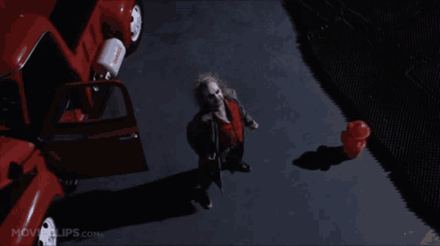 a movie clip from movieclips.com shows a woman standing in front of a red car