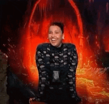 a woman is laughing while standing in front of a volcano .