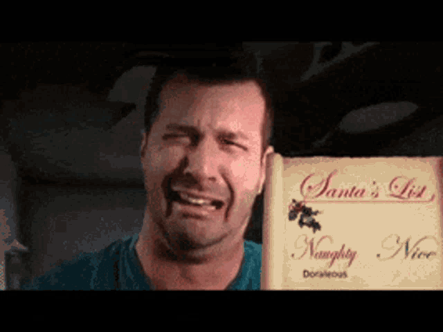 a man is crying while holding up a santa 's list