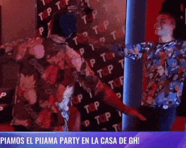 two people are dancing in front of a wall that says top