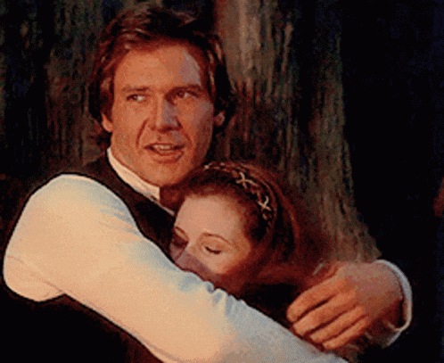 a man and a woman are hugging each other in front of a tree