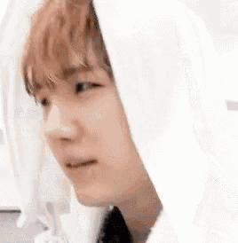 a close up of a person wearing a white hoodie with a hood on their head .