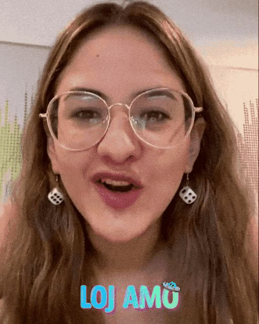 a girl wearing glasses and dice earrings says " lojamu " on the bottom