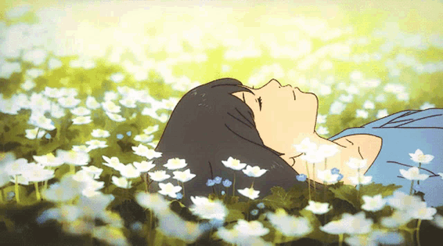 a woman laying in a field of flowers with her eyes closed