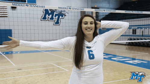 a middle tennessee volleyball player stands in front of the net