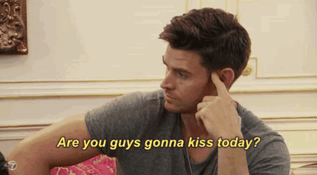a man with his finger on his ear is asking if he guys gonna kiss today