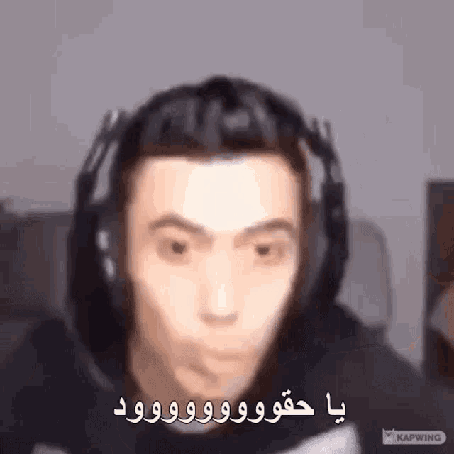 a man wearing headphones is making a funny face and talking in arabic .