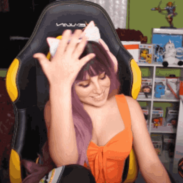 a woman wearing a cat ear headband sits in a black and yellow chair