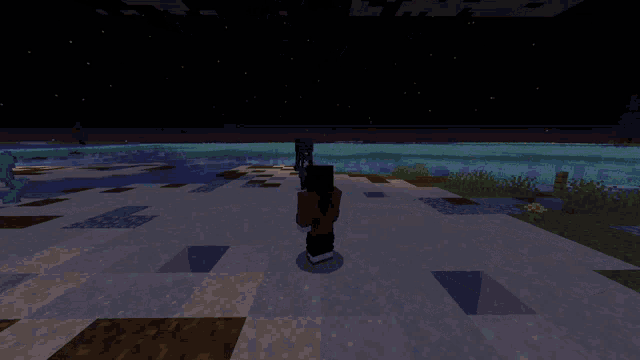 a person in a red shirt is standing in front of a body of water at night