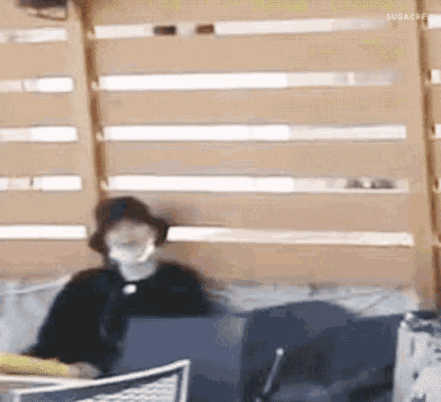 a person wearing a mask is sitting on a couch .