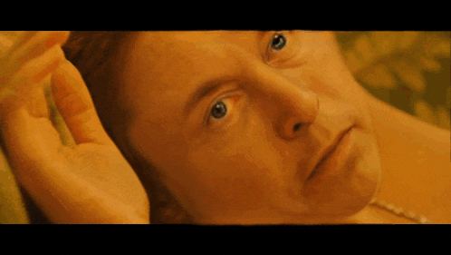 a close up of a man 's face with his hand on his face